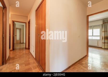 Distributor corridor with oak parquet flooring, wooden doors and access to several rooms Stock Photo