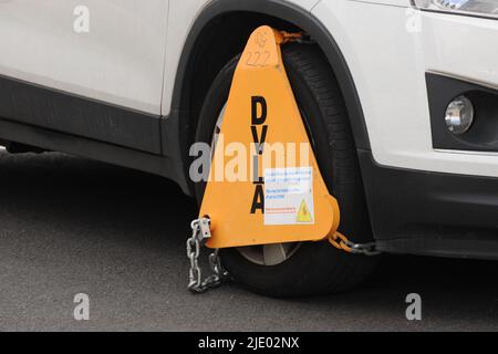 uninsured or untaxed vehicle clamped by roadside Stock Photo