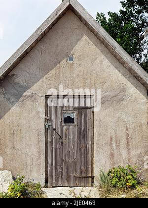 Old stone fisherman's hut with wooden door, fishing spot, seasonally inhabited village on the coast, Norebod Fiskelaege, southern Gotland, Gotland Stock Photo