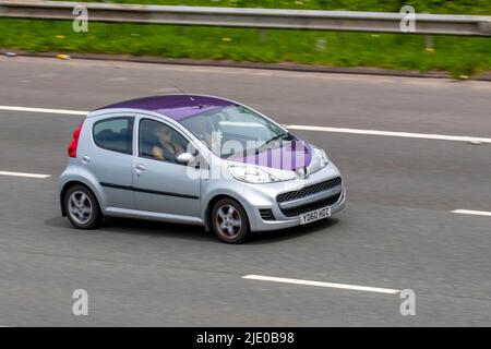 2010 purple custom Peugeot 107 Allure, silver hatchback 998cc petrol hatchback; travelling on the M61 Motorway, Manchester, UK Stock Photo