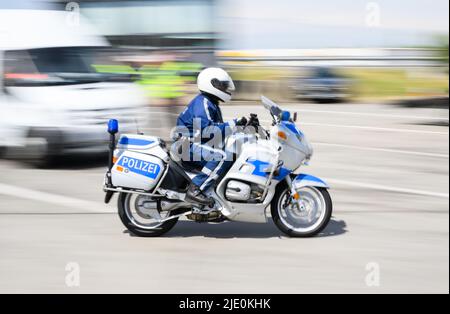 24 June 2022, Saxony, Bad Gottleuba-Berggießhübel: Police officer riding his motorcycle along the German-Czech border during a temporarily reintroduced border control. The controls are carried out flexibly in terms of time and place on the occasion of the upcoming G7 summit in Elmau. (Shot with long exposure time) Photo: Robert Michael/dpa Stock Photo
