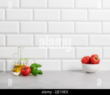 Ripe tomatoes basil garlic bottle of oil on the background of a white tiled wall, kitchen Stock Photo