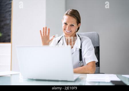 Doctor Having Video Conference On Laptop With Colleagues Stock Photo