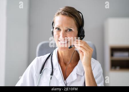 Close-up Portrait Of Confident Receptionist Using Headset In Hospital Stock Photo