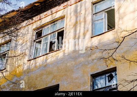 Abandoned building with broken windows. A fragment of the facade. Desolation Stock Photo