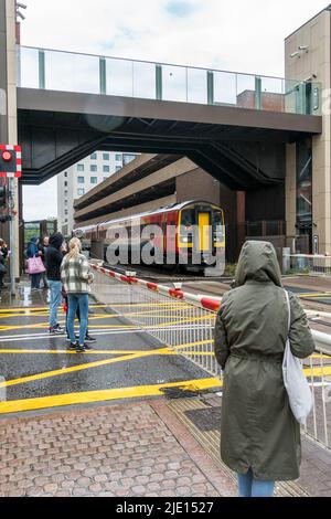 East Midlands Railway Regional two car diesel train passing under pedestrian bridge High street Lincoln city 2022 Stock Photo