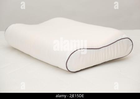 Orthopedic pillow made of memory foam on a white background. A Useful Right Pillow for Healthy Sleep Stock Photo