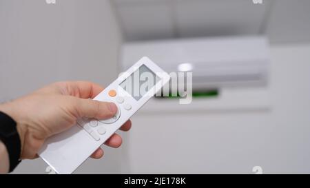 Person manual air conditioner with remote control closeup Stock Photo