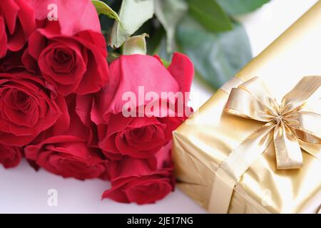 Valentines gift boxes tied with a red satin ribbon bow on red