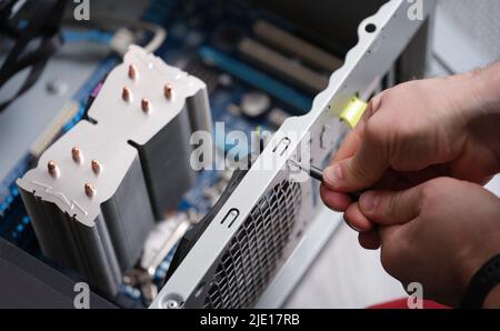 Technician repairing computer power supply closeup, Computer disassembly Stock Photo