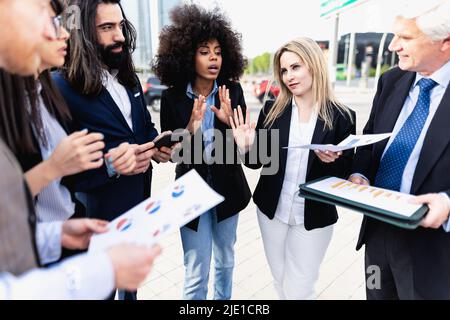 Multiracial business people having a briefing outside the office Stock Photo