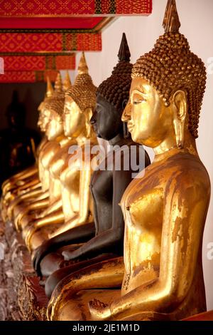 Row of Sitting Buddhas inside Wat Pho, Bangkok, Thailand Stock Photo