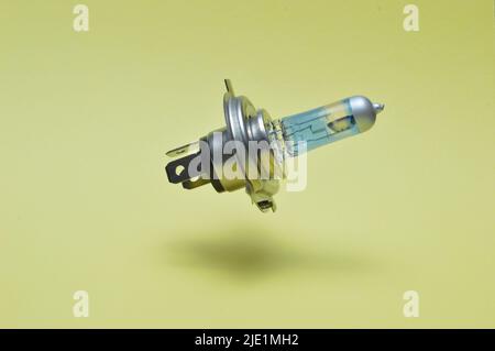 Halogen car headlight bulb isolated on yellow Stock Photo