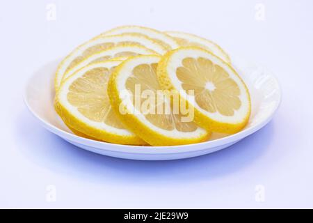 Sliced lemons on a white plate isolated on white background Stock Photo