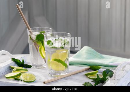 Summer refreshing mojito cocktails with lime and mint on a white wooden tray. Stock Photo