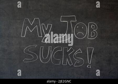 My job sucks written in chalk on a blackboard. Handwritten Stock Photo