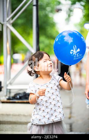 Montreal, Canada - June 24 2022: Little girl waving the Quebec ballon in Quebec day Parade in Montreal downtown Stock Photo