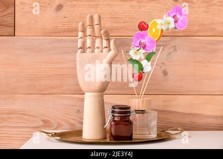 Aroma reed diffuser with candle and mannequin hand on table in room Stock Photo