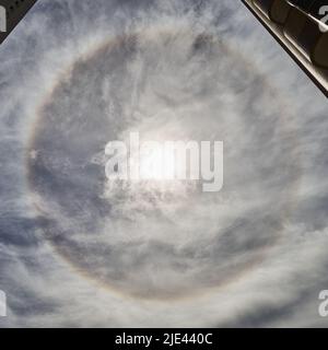 Taichung, Taiwan. 25th June 2022. A rare sun halo appeared over Taichung, Taiwan on Saturday morning, June 25, 2022.  Sun halos appear when light his tiny ice crystals found in cirrus clouds.  Light is then refracted and reflected to form a 'halo' or ring around the sun. The circle around the sun is approximately 22 degrees.  Sun halo information obtained from earthsky.org.  Credit: Kevin Williams/Alamy Live News. Stock Photo