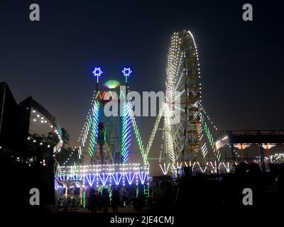 Giant wheel carnival ride or Ferris wheel flyer ride in Indian village fair ground at night Stock Photo