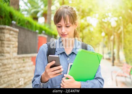 Focused young female student checking her phone Stock Photo