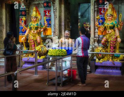 A priest and worshippers in the Sri Veeramakaliamman Temple, Serangoon Road, Little India, Republic of Singapore.  This Hindu temple is one of the old Stock Photo