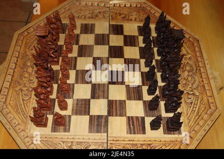 Old brown and black chess pieces carved in the Mayan style Stock Photo