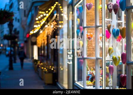 Plastic hearts exposed in a gift shop showcase on a night street Stock Photo