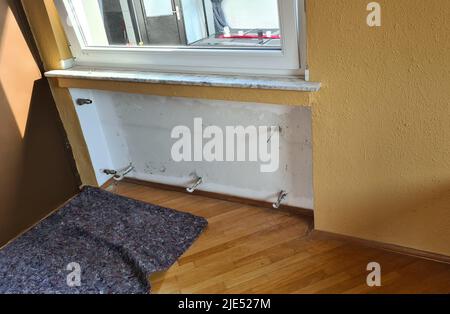 Dismantling a broken radiator in a private house. Radiator. Stock Photo