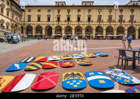 Colourful shields lined up on Piazza Grande prior to fixing to buildings on square - Piazza Grande in historic city centre of Arezzo in Tuscany, Italy Stock Photo