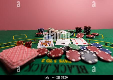 A closeup cards and different chips spread on a poker table Stock Photo