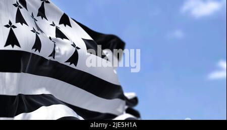 Rear view of the Brittany flag waving in the wind on a clear day. Brittany is a peninsula, historical country, and cultural area in the west of France Stock Photo