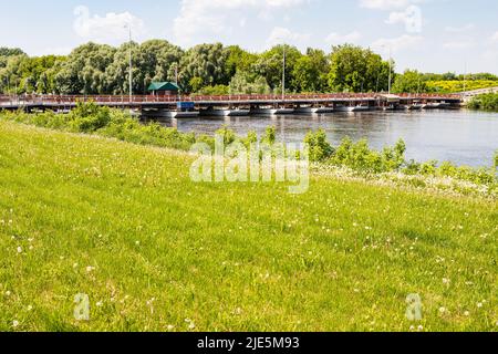 view of Bobrenevsky pedestrian movable pontoon bridge across Moskva River in Kolomna city on sunny summer day Stock Photo