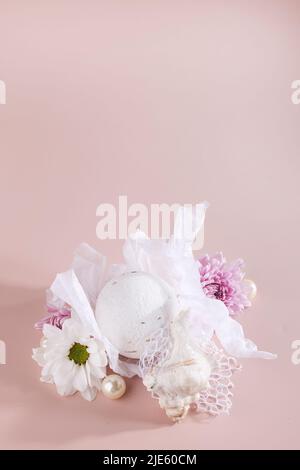 bath bomb, flowers and seashell on beige background. Still life, relax, wellness concept. copy space. Skincare and spa style. Stock Photo