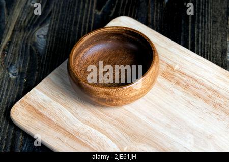 wooden plate on cutting board and black wooden table, empty round wooden plate on table Stock Photo