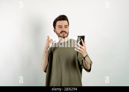 Handsome young man wearing casual clothes posing isolated over white background doing phone gesture with hand and fingers like talking on the telephon Stock Photo