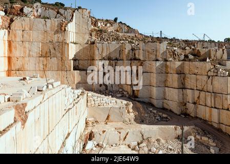 Rock wall, ramps, blocks and excavators in the marble quarry near Orosei on the east coast of Sardinia, Baronia,Italy Stock Photo