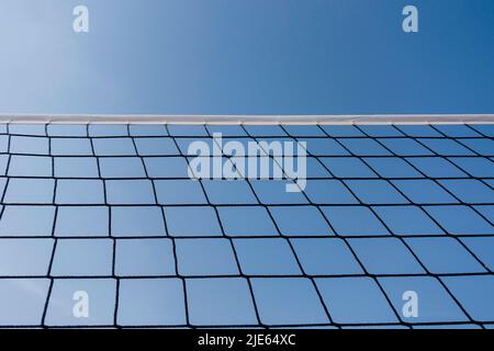 Tennis or volleyball net against clear blue sky background. Outdoors sports field in sunny day Stock Photo
