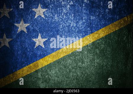 Closeup of grunge Solomon Islands flag. Dirty Solomon Islands flag on a metal surface. Stock Photo