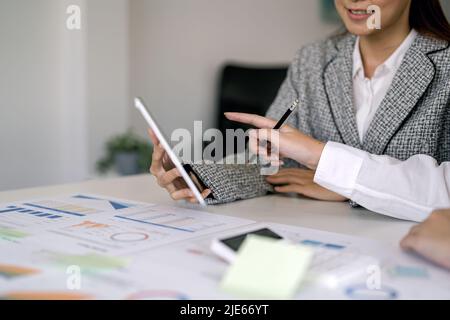 Business team analyzing income charts and graphs to plan marketing concept with using digital tablet and calculator for analysis Stock Photo