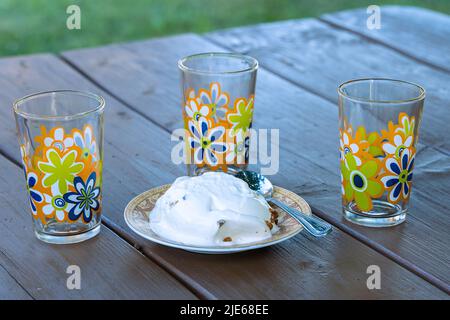 The portion of ice cream and three empty glasses  on the table. Stock Photo