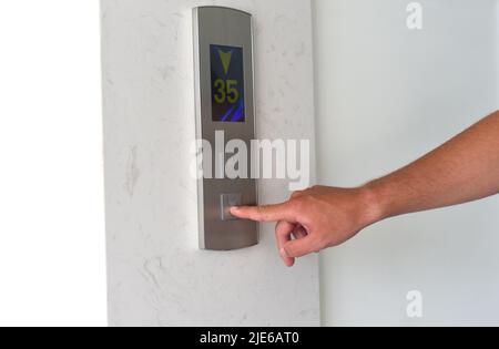 A hand pressing lift button Stock Photo