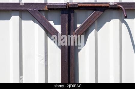 Latch on the gate. Design for locking the gate from the inside. Old rusty padlock on a metal fence. Locking latch on the gate Stock Photo