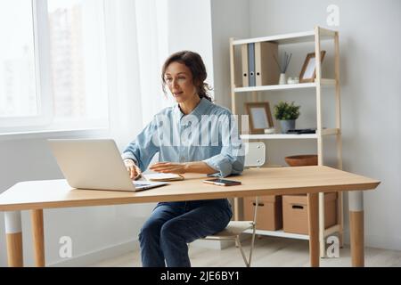 Candidate on vacant place answering question of hr in online meeting using laptop. Curly awesome cheerful attentive woman interested listens to Stock Photo