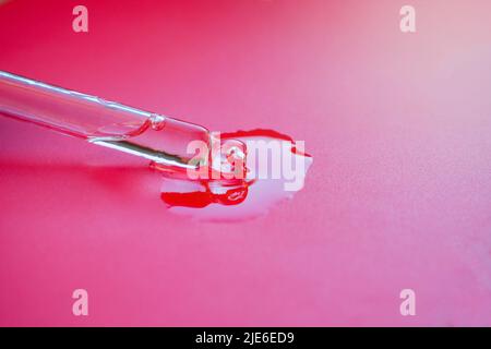 Close-up pipette on a raspberry background with essential oil, facial cosmetics. Cosmetology body care, aroma oils Stock Photo
