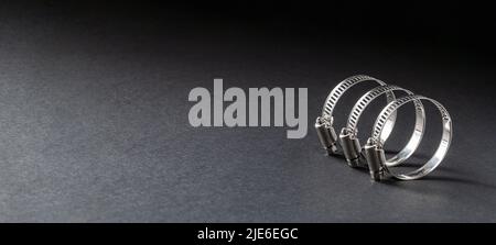 Metal hose clamp on black background. Empty space for text Stock Photo