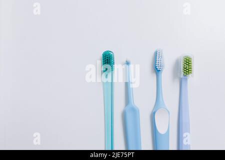 Four toothbrushes at different heights on a white background. High quality photo Stock Photo