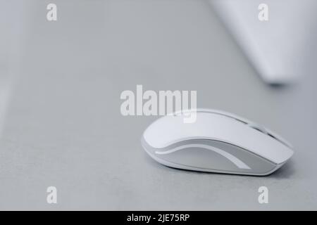 White bluetooth mouse for computer on a gray table. High quality photo Stock Photo