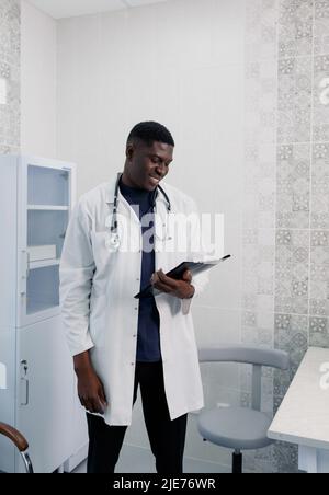 A picture of a handsome young doctor standing alone in his clinic. Stock Photo