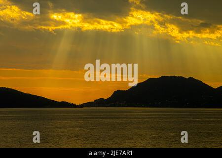 stormy sky over the sea , the rays of the sun break through the clouds Stock Photo